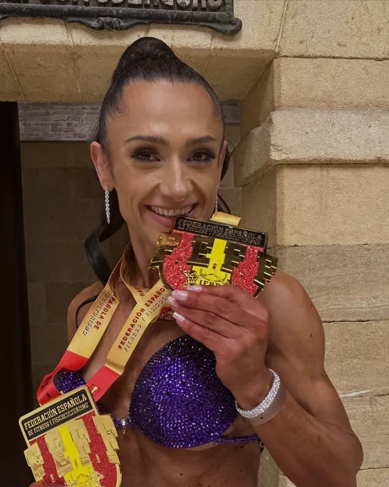 Gina Balicoi somrient amb les medalles de la Federació Espanyola de Fitness, en una competició