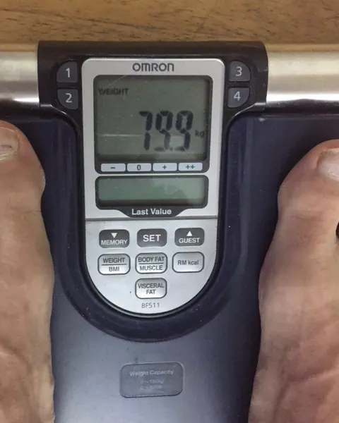 Uns peus damunt d'una bàscula de composició corporal OMRON que marca 79,9 kg