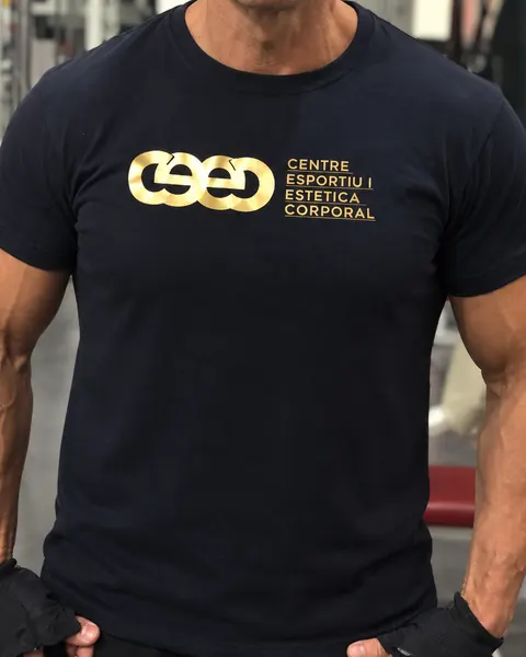 Un entrenador amb la samarreta negra del CEEC, amb el logo i «Centre Esportiu i Estètica Corporal» en daurat