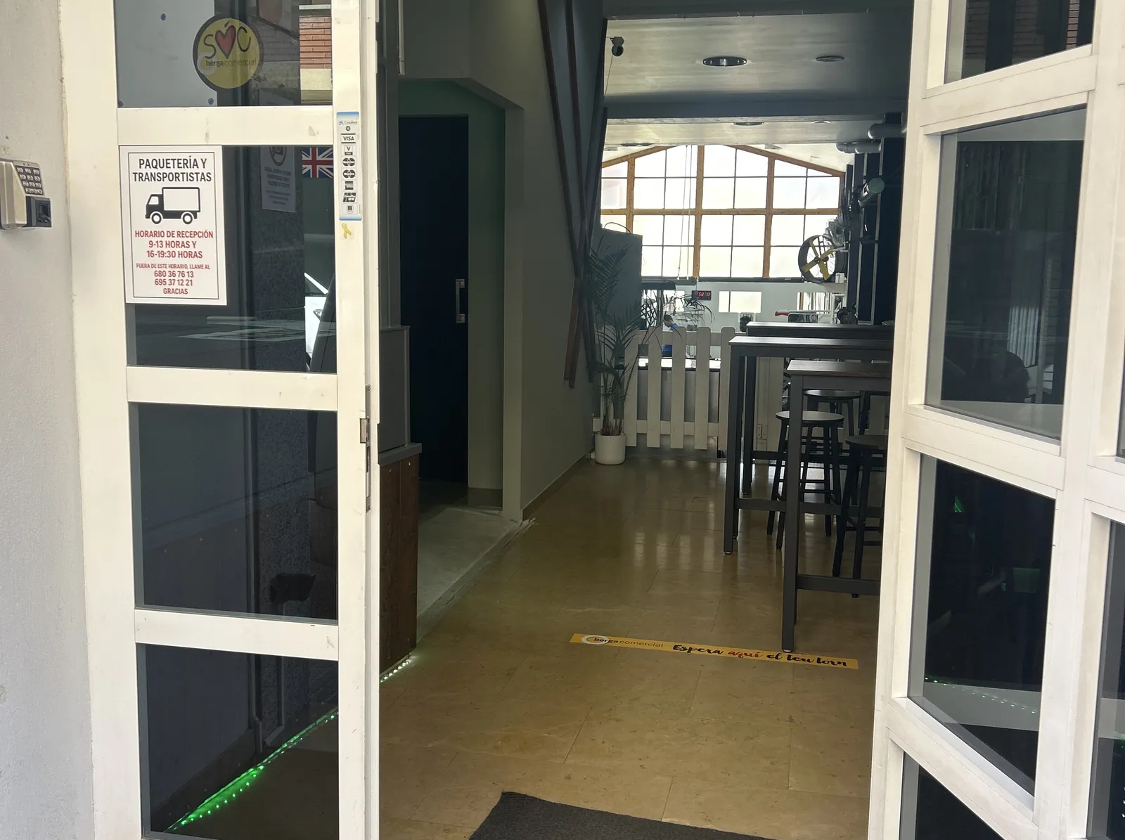 La porta del CEEC oberta: el passadís de l'entrada i el finestral del fons